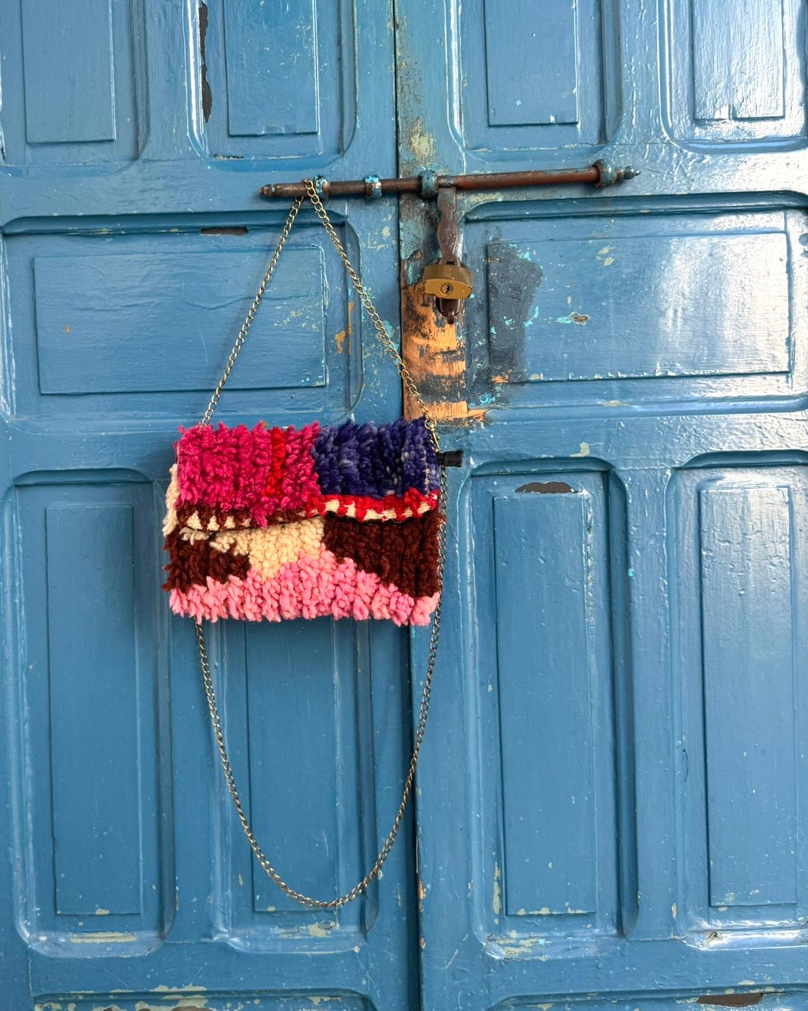Gekleurde tas hangt aan een blauwe deur