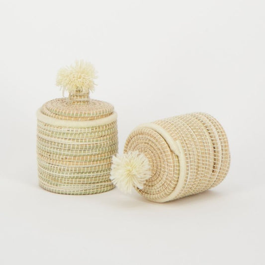 Handgemaakte raffia manden met pompondeksel, vervaardigd door vakmensen in Marokko, ideaal voor decoratie en praktische opslag.