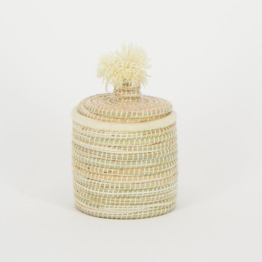 Handgemaakte raffia mand met pompondeksel, vervaardigd door vakmensen in Marokko, ideaal voor decoratie en praktische opslag.